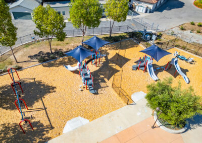 A modern school playground with separate sections for ages 2–5 and 5–12.