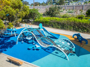 An angled view of the playground's wave-like design and integrated shades.